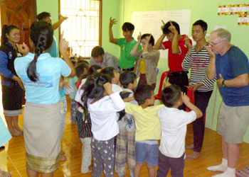 Preschool children and adults learn Lao sign language.