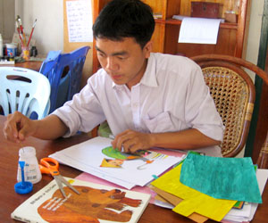 Tha Thao works on his next book, pictures of animals cut from paper.