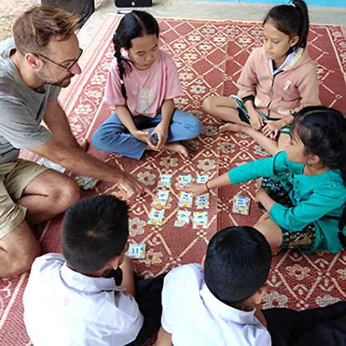 Lao students play a game trying to make an equation with 3 or more numbers from 9 cards dealt.