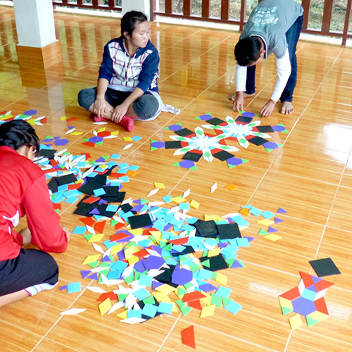 Children making pictures and designs with small colorful tiles of many shapes