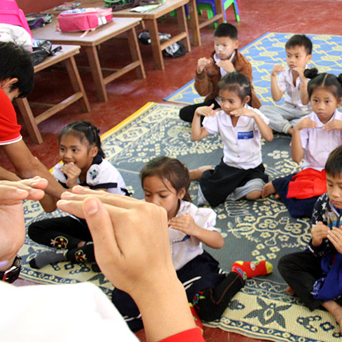 Students learning Lao sign language, putting the tips of their fingers together