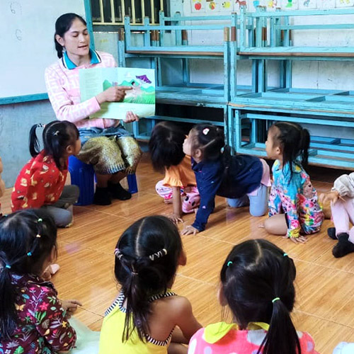 A teacher reads a picture book aloud to children