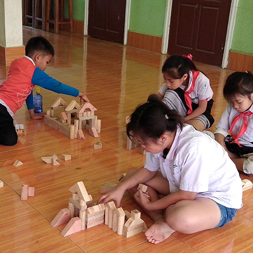 Children playing with small wooden blocks